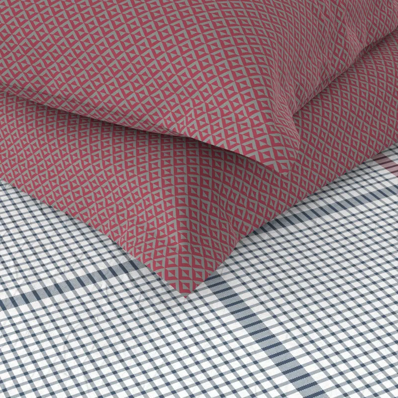 Close-up of red geometric patterned pillows over the checked bedsheet
