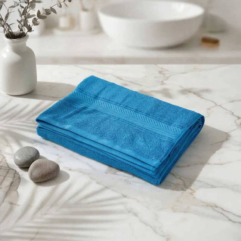 Folded vivid blue bath towel on a marble countertop