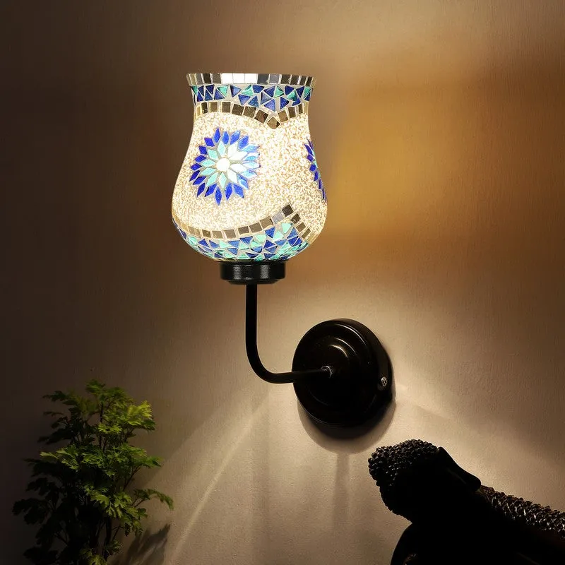 Lit mosaic glass wall lamp with blue floral motif and black iron arm