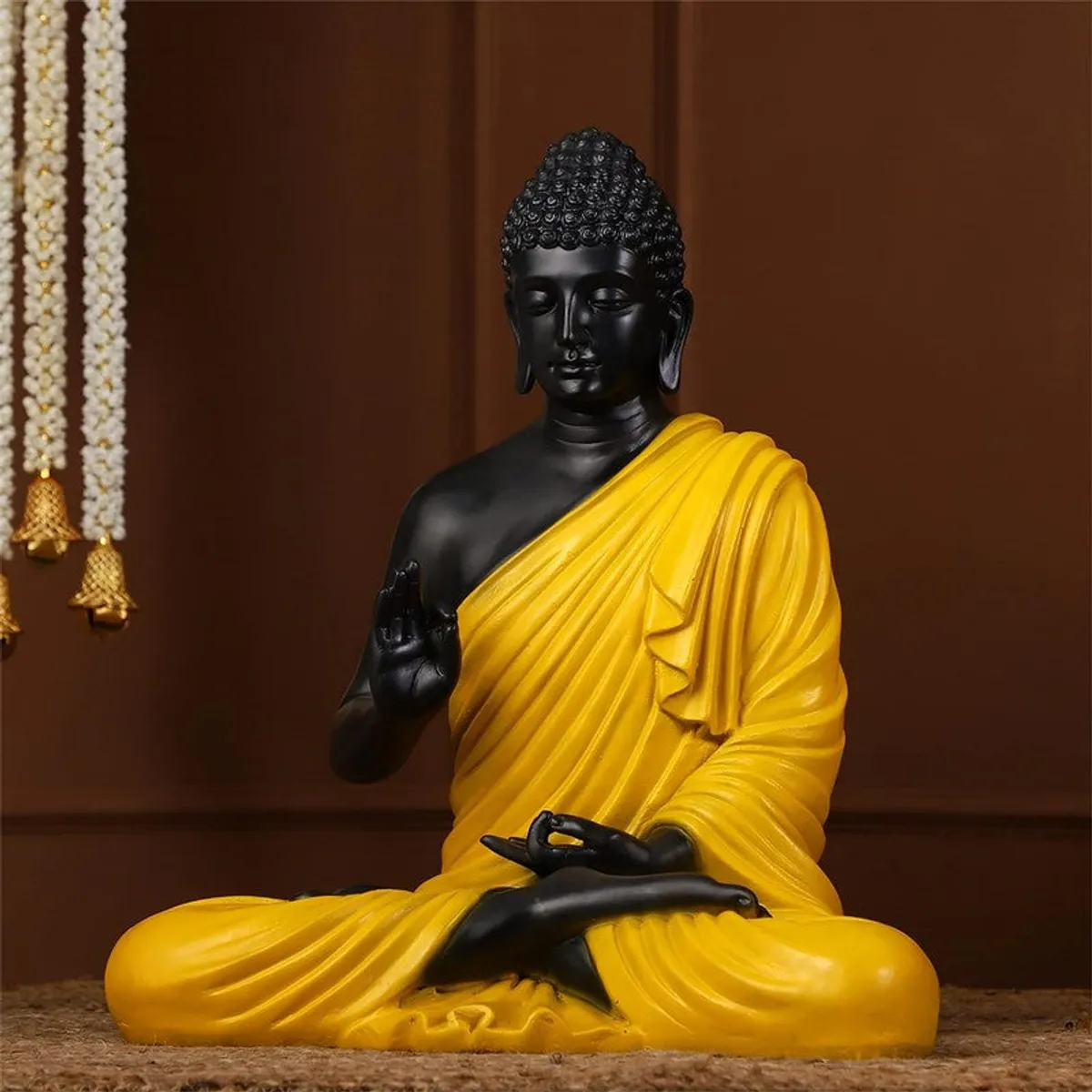 Front view of seated Buddha idol in black and yellow