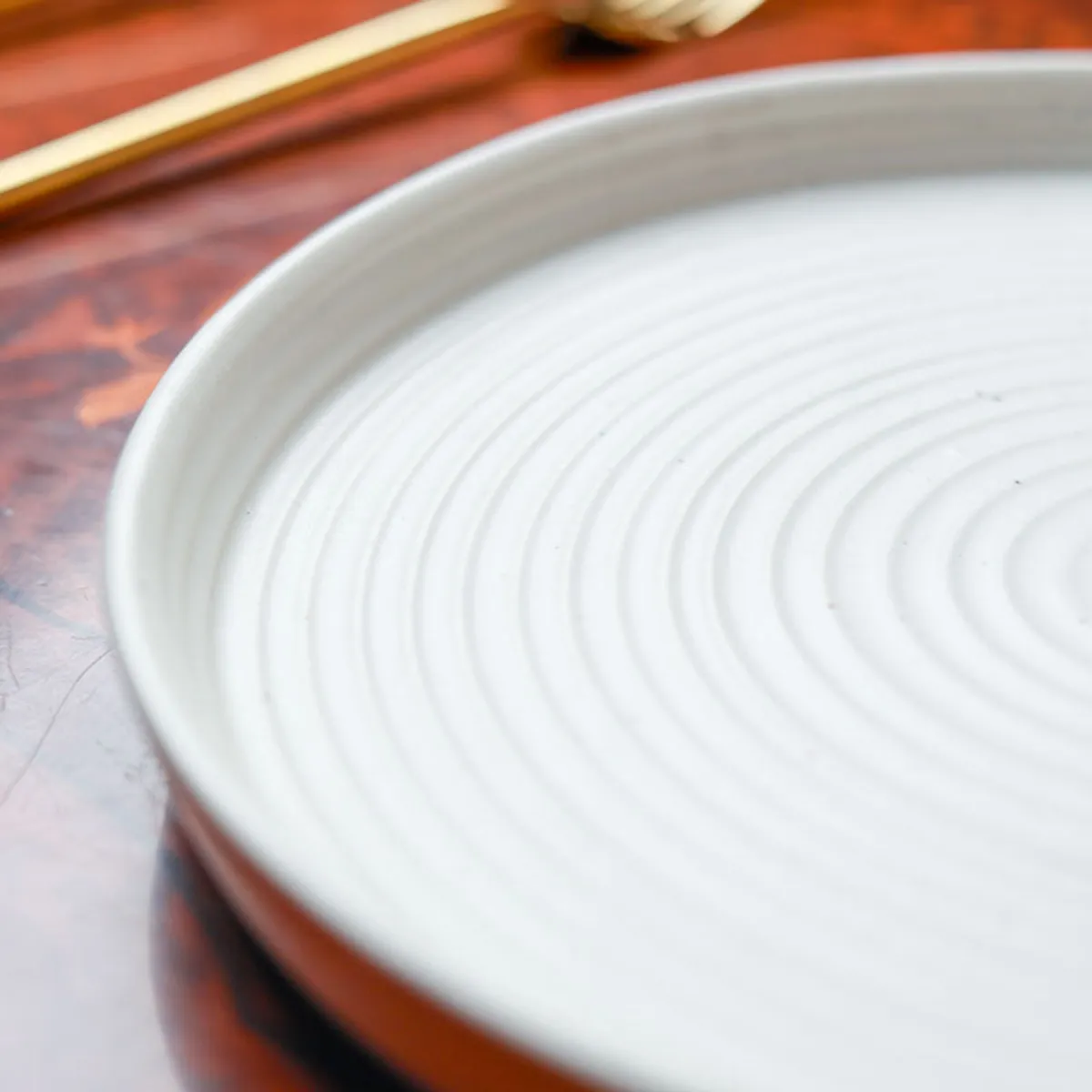 Side view showing the shallow profile of a white ceramic plate