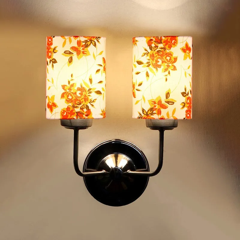 Close view of lit wall lamp with two floral cotton shades