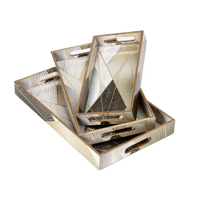 Three black and gold serving trays stacked to show their handled edges
