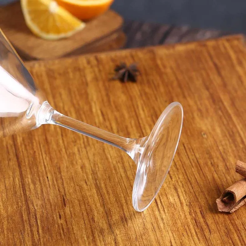Close-up of the base and stem of a clear cocktail glass on a wooden surface