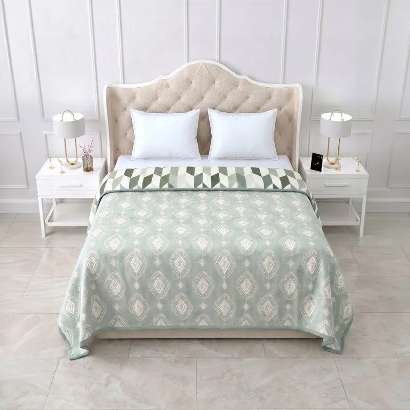 Olive green reversible dohar with white ethnic print spread over a bed