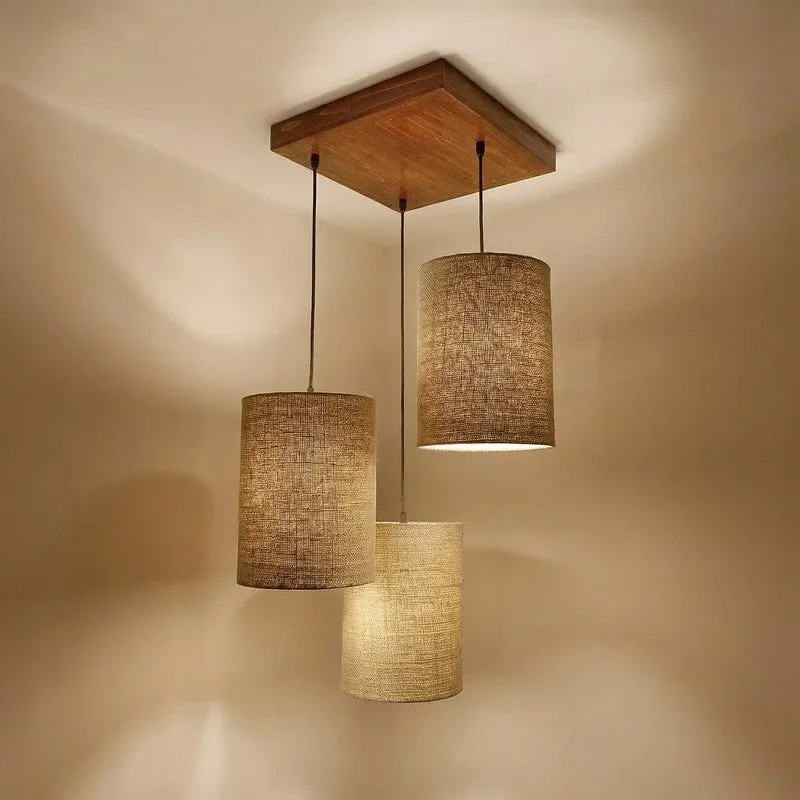 Three pendant cylindrical shades hanging from a square wooden canopy