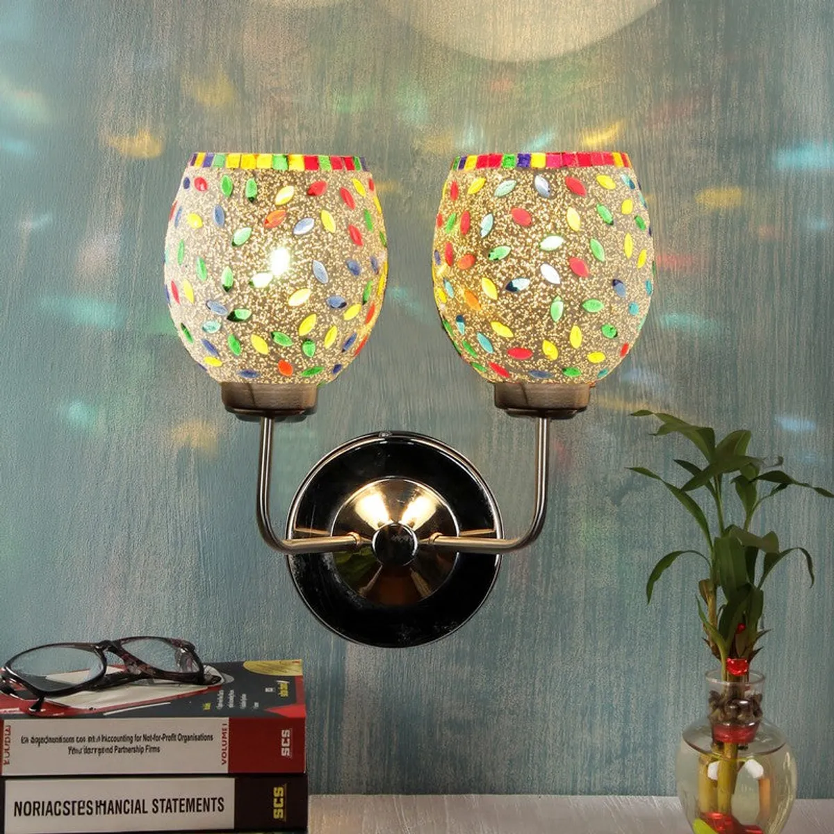 Lit multicolour mosaic glass wall lamp casting colourful glow upward