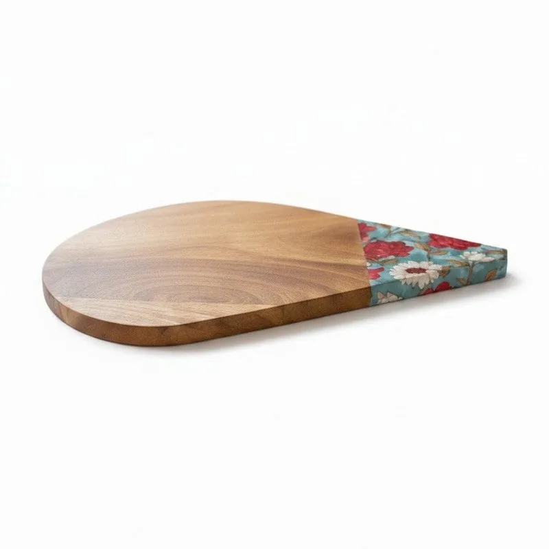 Mango wood platter showing its rounded free-form shape and floral aqua-and-red detail