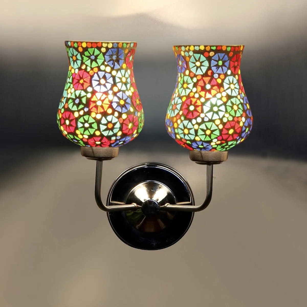 Close view of lit dual mosaic glass wall lamp casting warm light