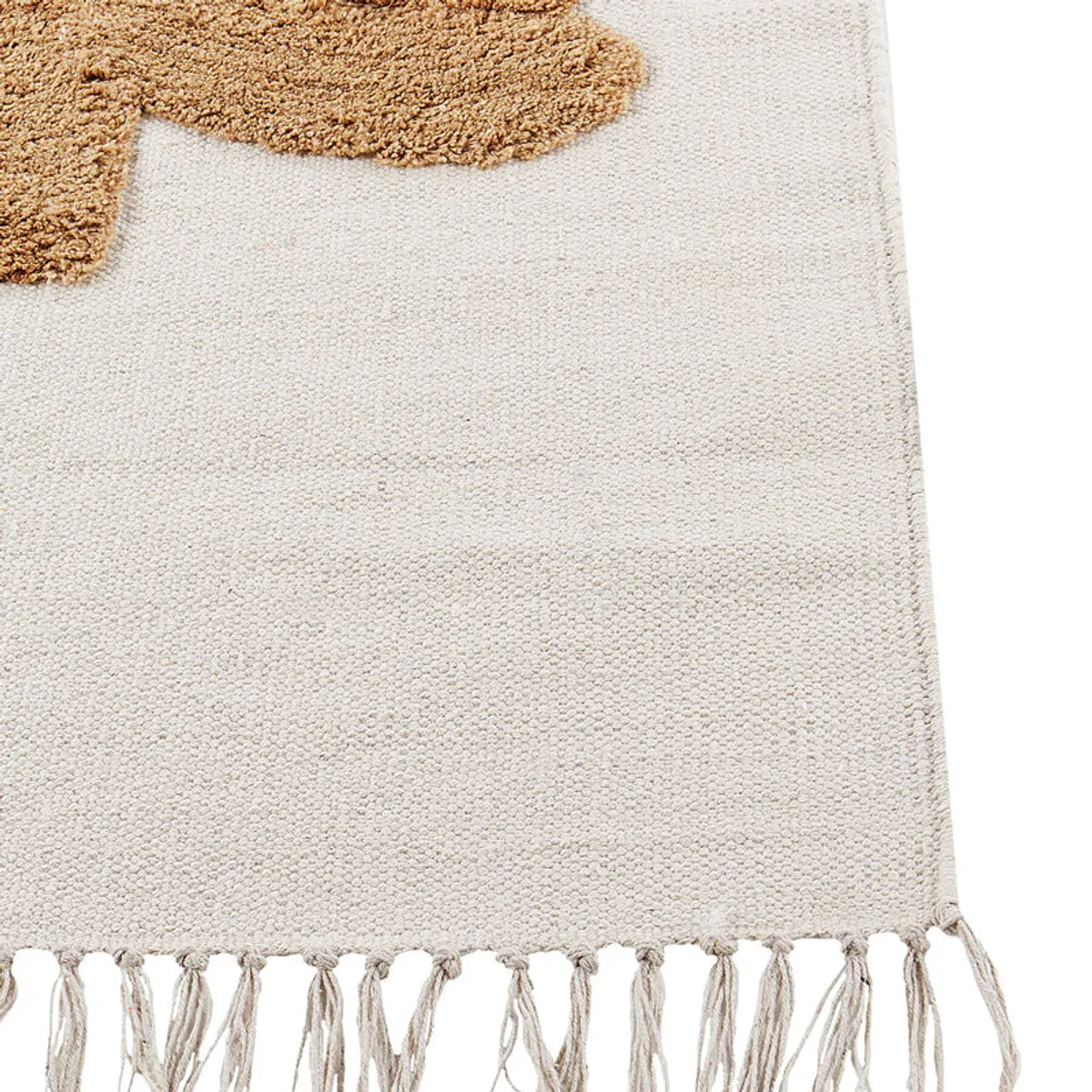 Close-up of the rug's cream textured cotton surface and ochre tufted motif