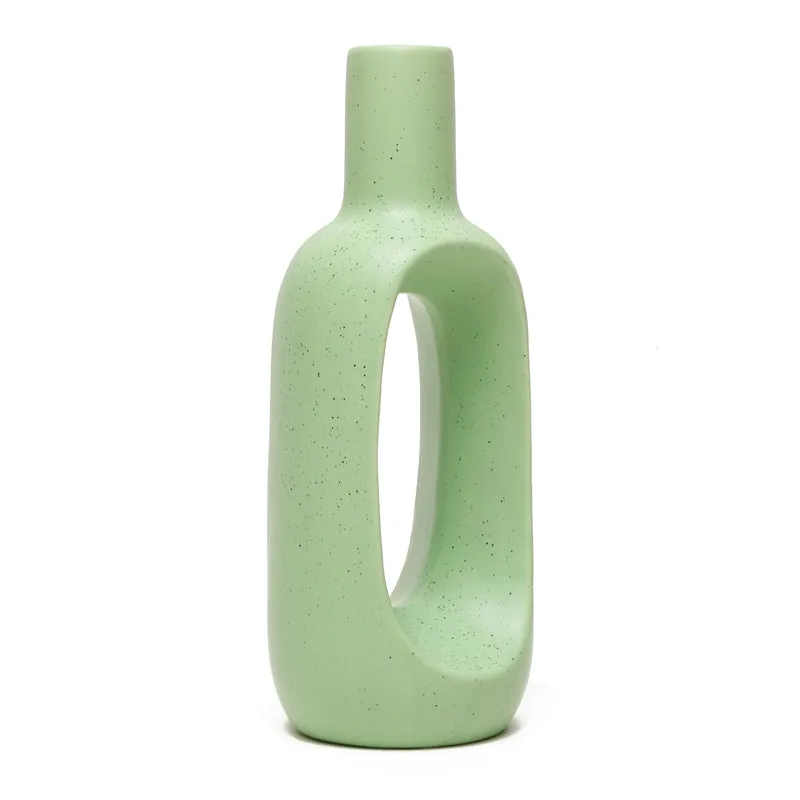Angled view of a green speckled donut vase with hollow centre