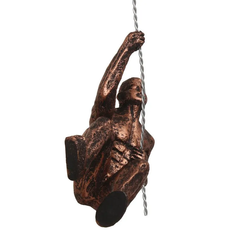 Low-angle view of bronze climbing figure wall hanging