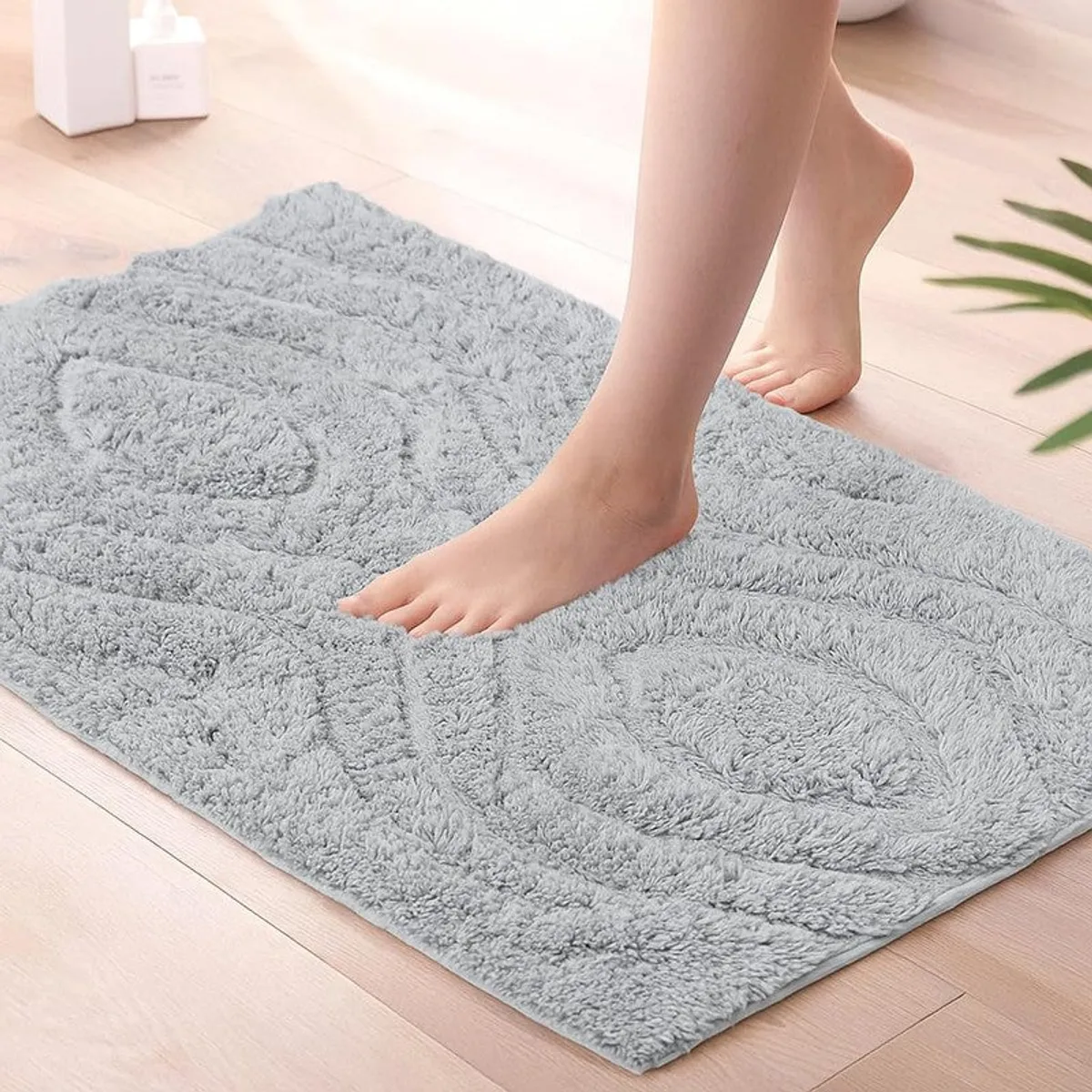 Close view of a grey textured bath mat underfoot