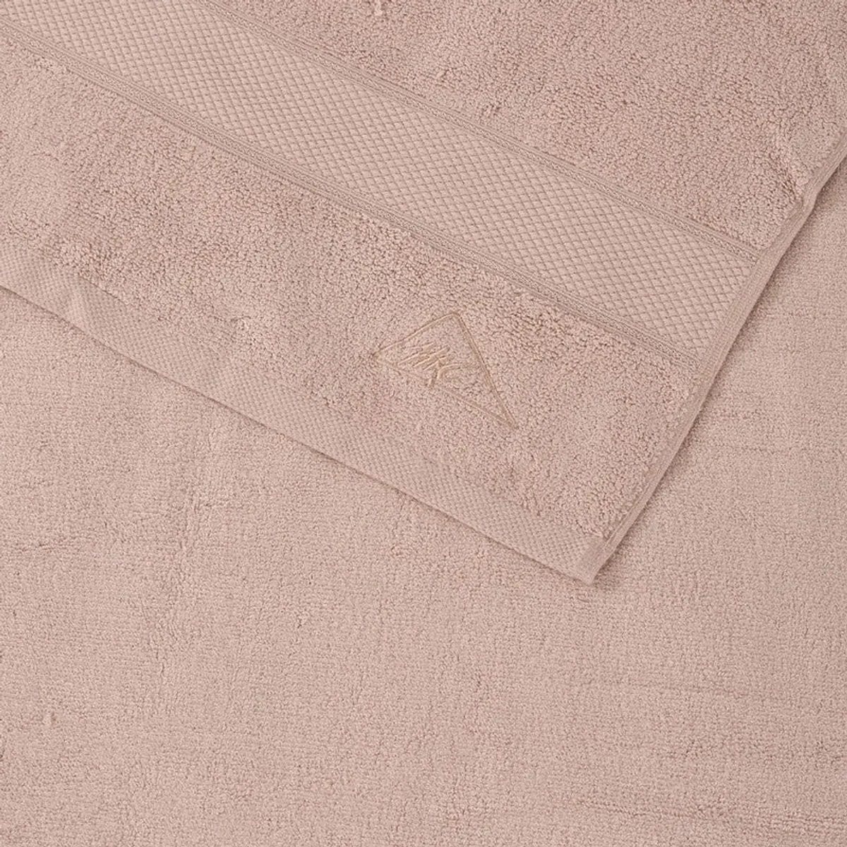 Close-up of the beige towel showing its textured bands and folded edge