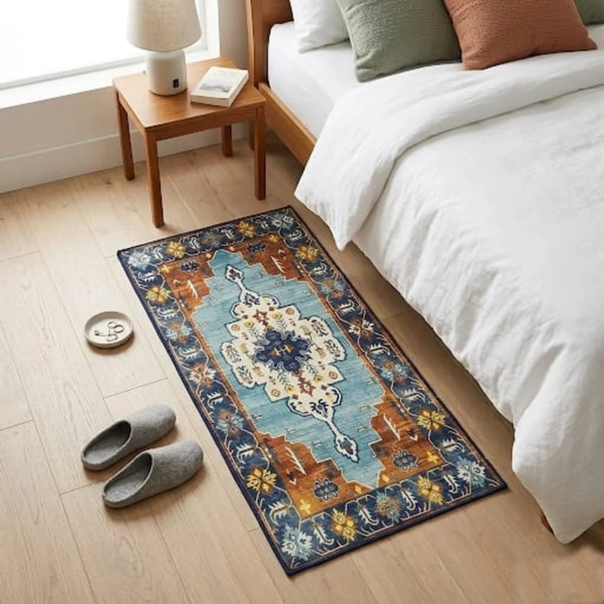 Blue and orange patterned carpet placed beside a bed in a bedroom