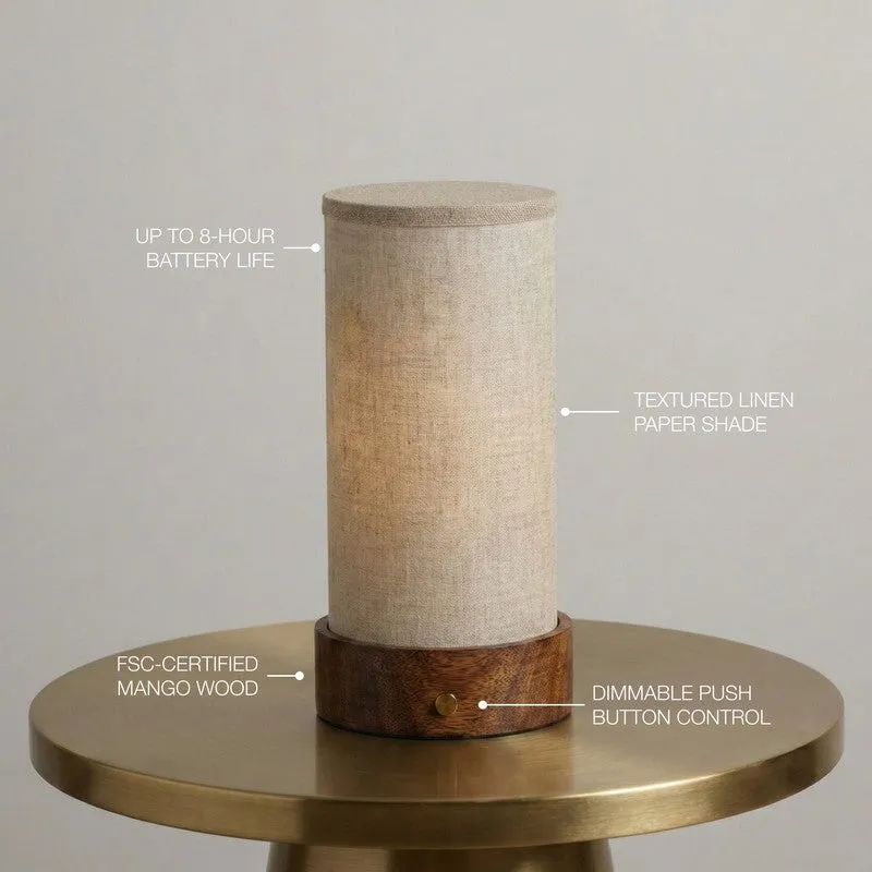 Beige cylindrical lamp on a brass table with feature callouts