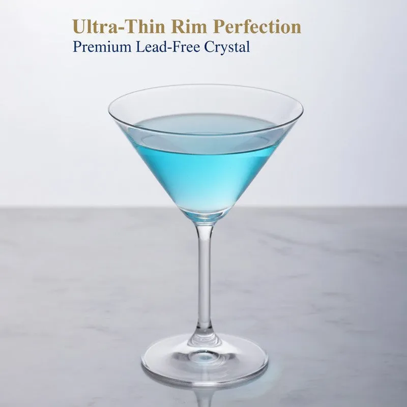 Single clear stemmed cocktail glass with blue drink on a light surface