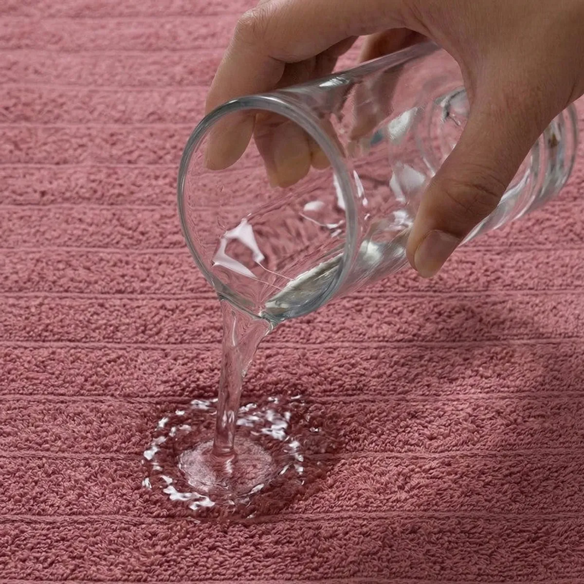 Close-up of water poured onto a pink textured towel