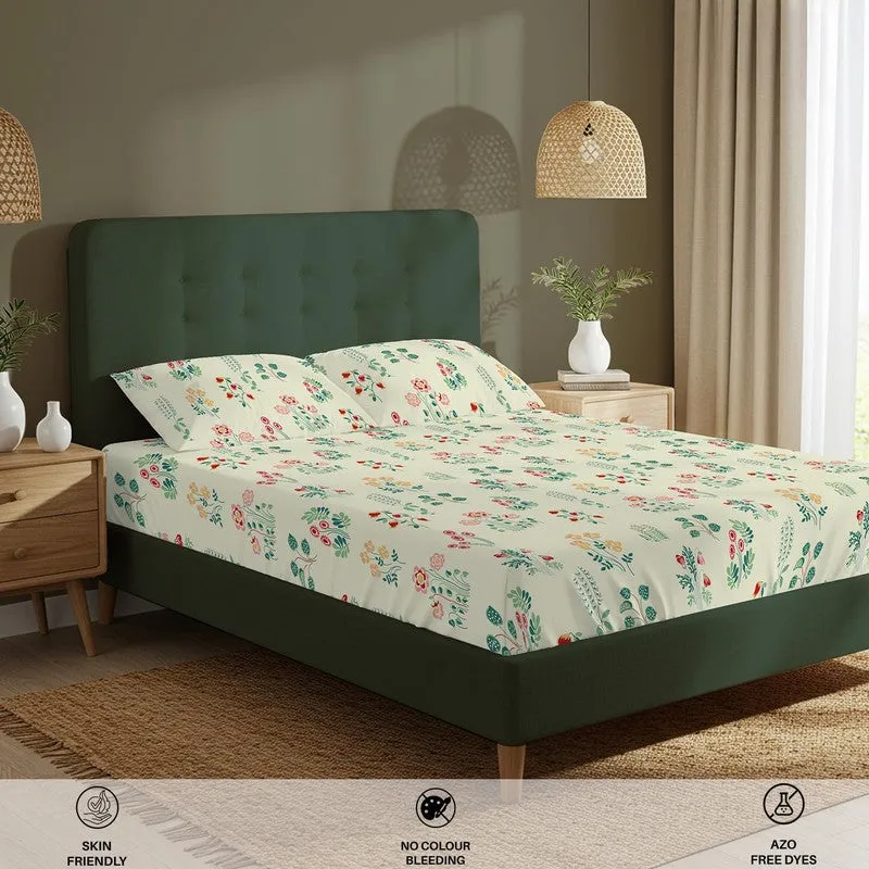 Angled view of floral fitted bedsheet set on a green upholstered bed