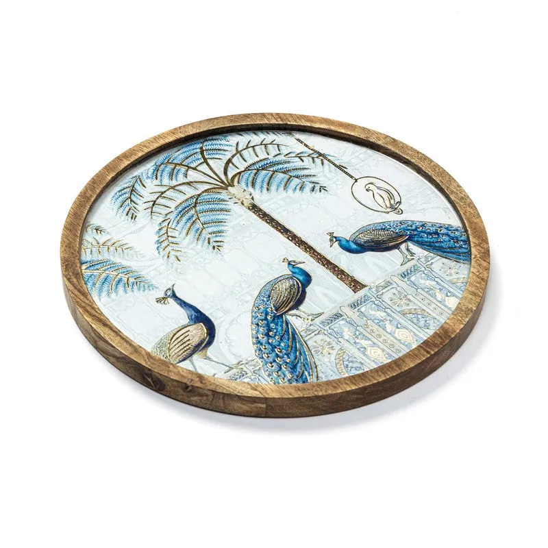 Round platter showing blue peacocks, palm leaves and an architectural scene
