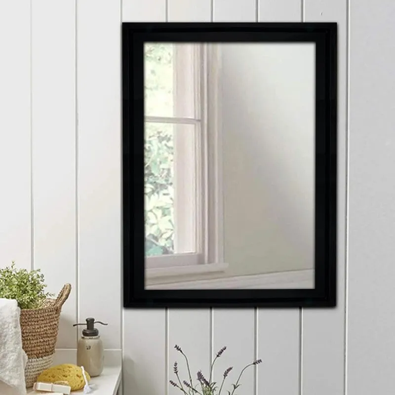 Black rectangular wall mirror mounted above a bathroom counter