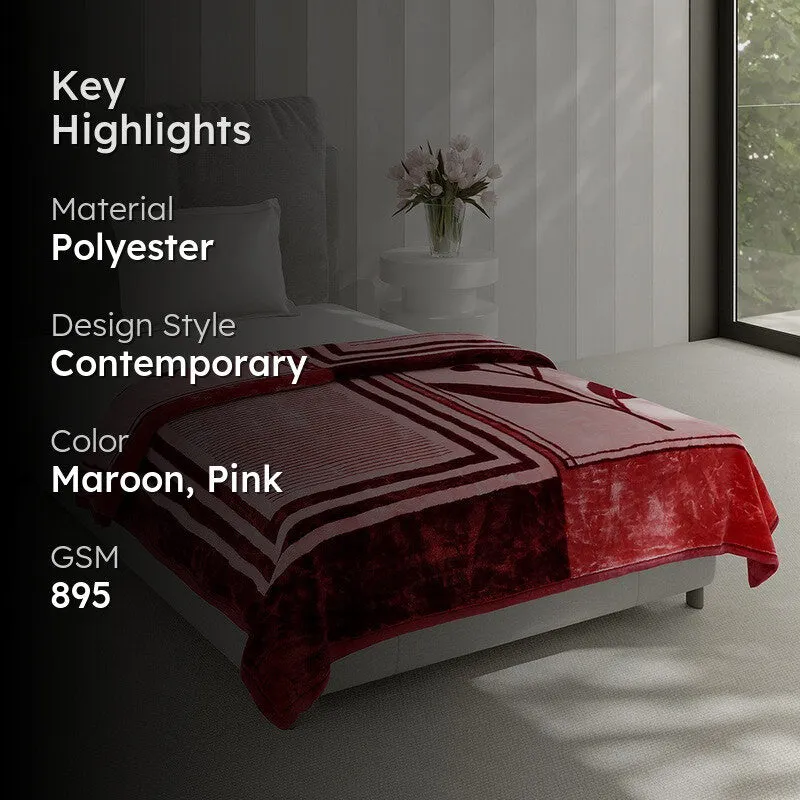 Maroon and pink geometric blanket styled on a contemporary bed