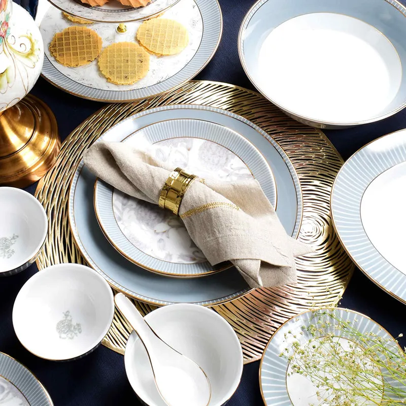 Dinnerware arrangement with grey floral plates, bowls, serving dishes and a folded napkin