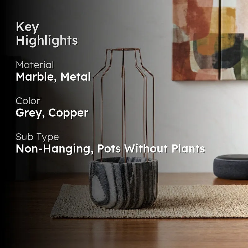 Grey marbled planter with copper frame styled on a wooden table