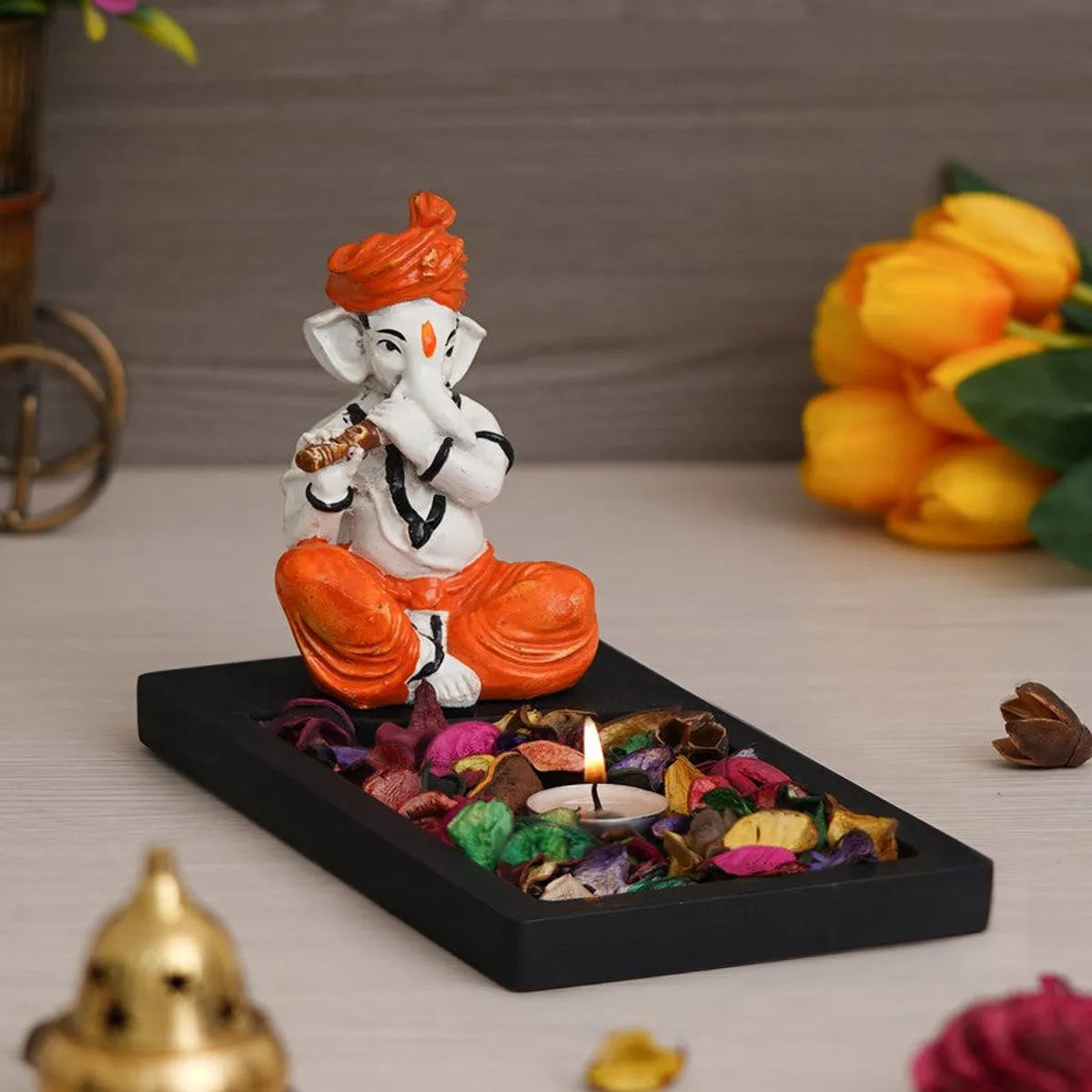 Angled view of Ganesha tea light candle holder on a black tabletop base