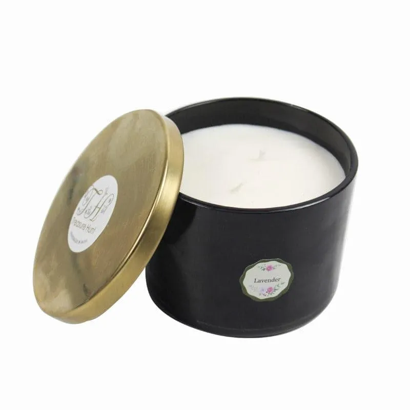 Black candle jar with white wax and a gold lid placed beside it
