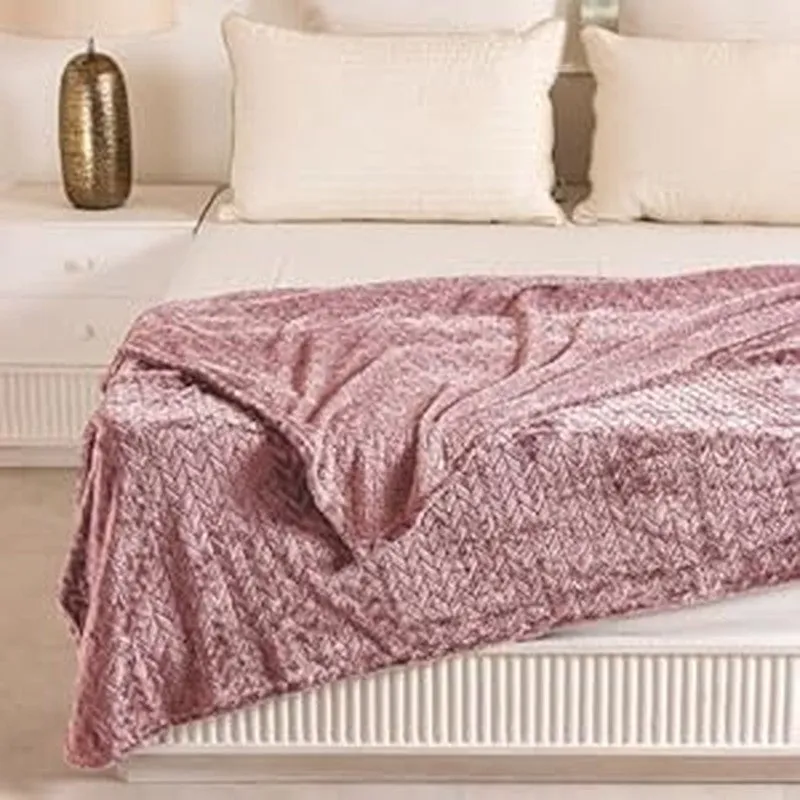 Peach textured blanket draped over a bed with pillows