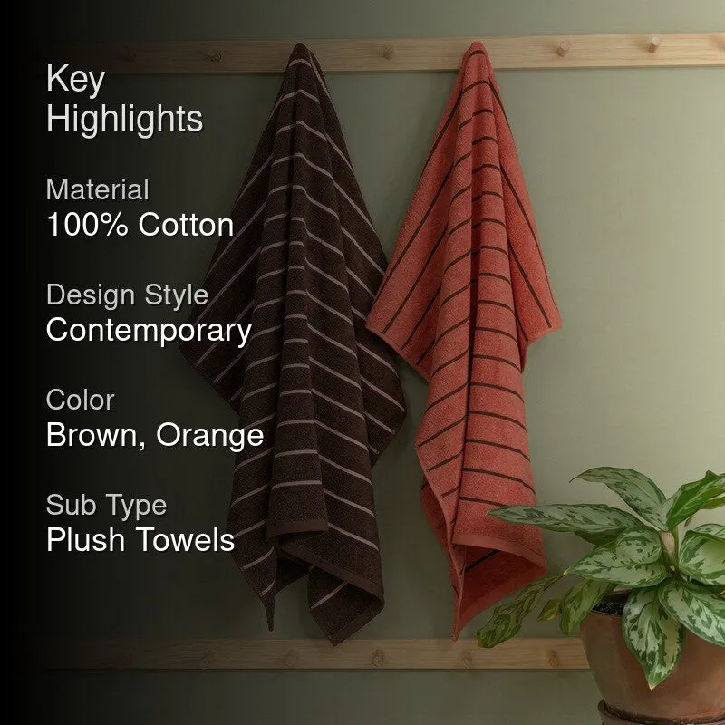 Brown and orange striped bath towels hanging in a bathroom setting
