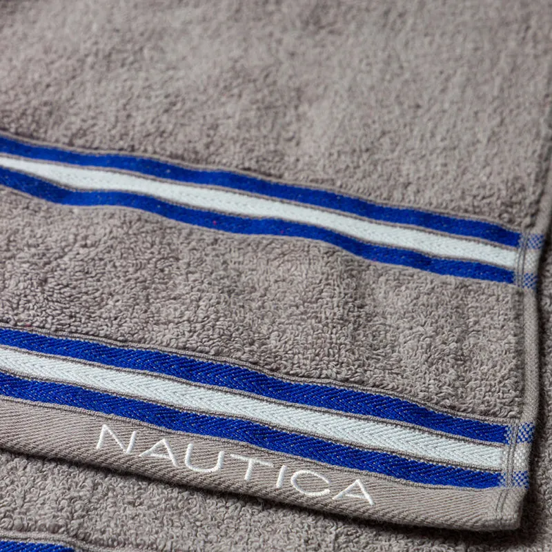 Close-up of beige towel showing blue and white striped edging