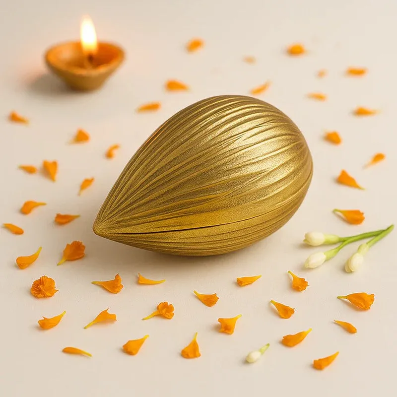 Closed golden almond-shaped candle resting among scattered flower petals