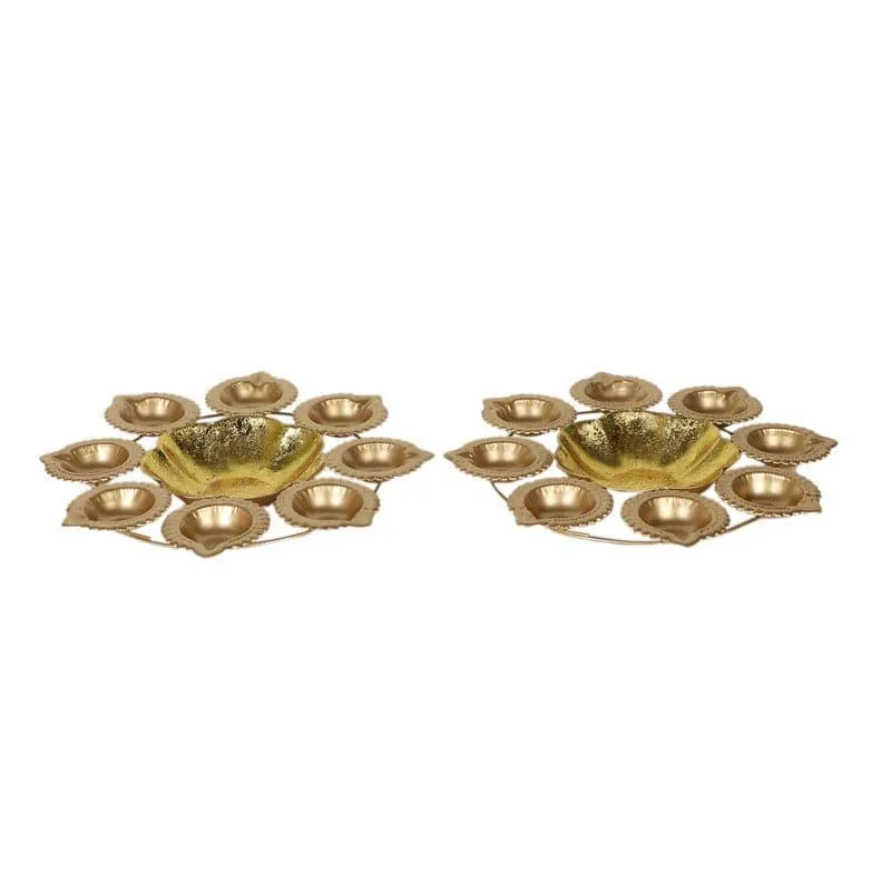 Two gold urli pieces with petal-shaped diya holders on a white background