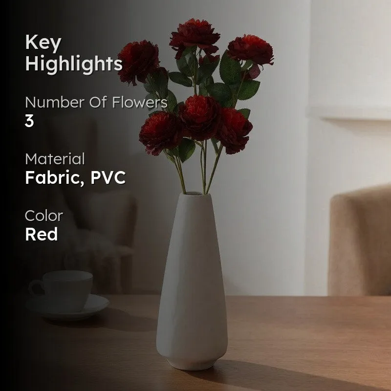 Red artificial rose flower arrangement in a white vase shown in a home setting.