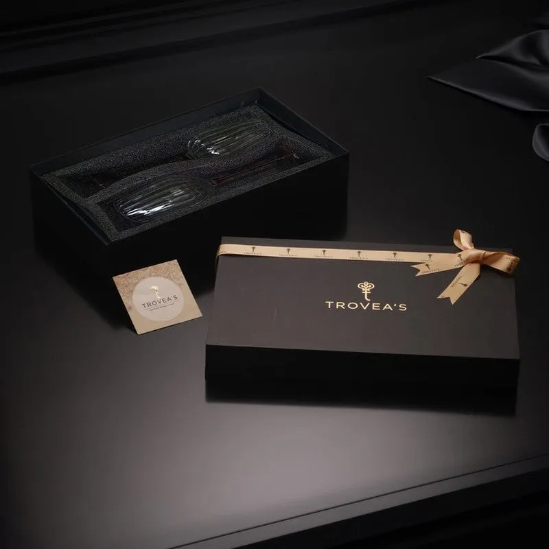 Two wine glasses presented in a dark gift-style box