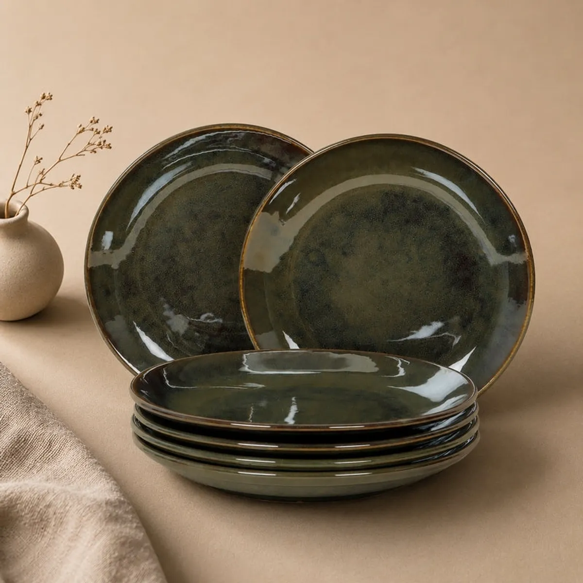 Olive green glossy plates stacked and displayed against a neutral backdrop