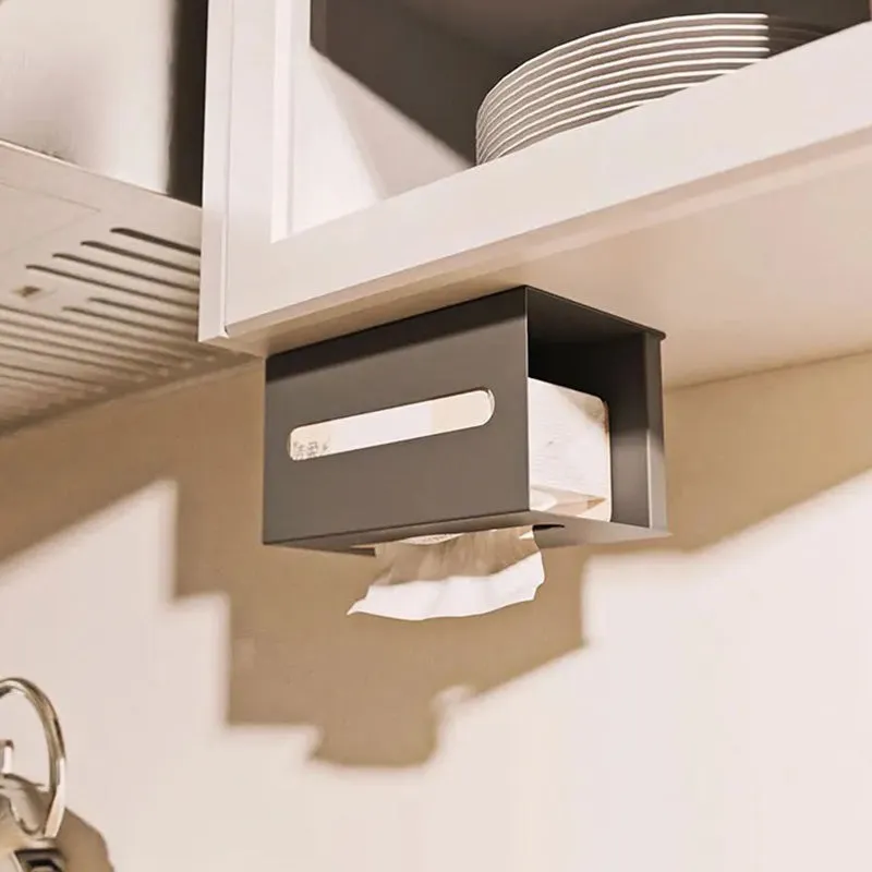 Black tissue holder mounted under a cabinet with tissue roll inside