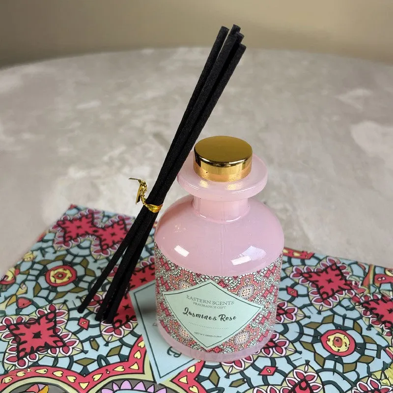 Close-up of pink glass diffuser with black reeds and a gold-toned cap