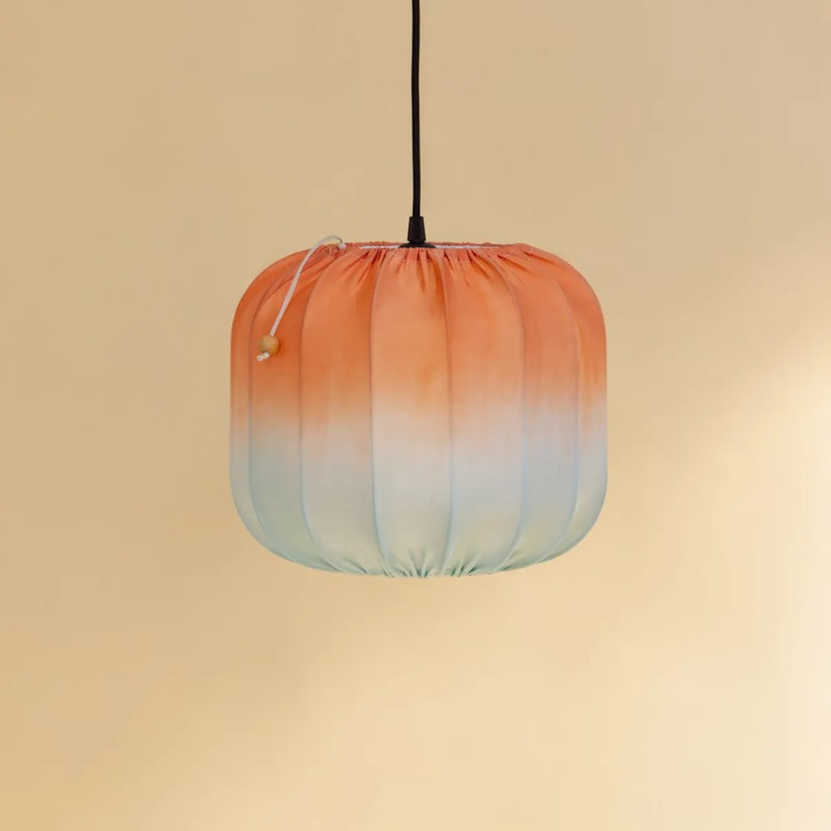 Pendant lamp showing its orange-to-blue gradient satin shade