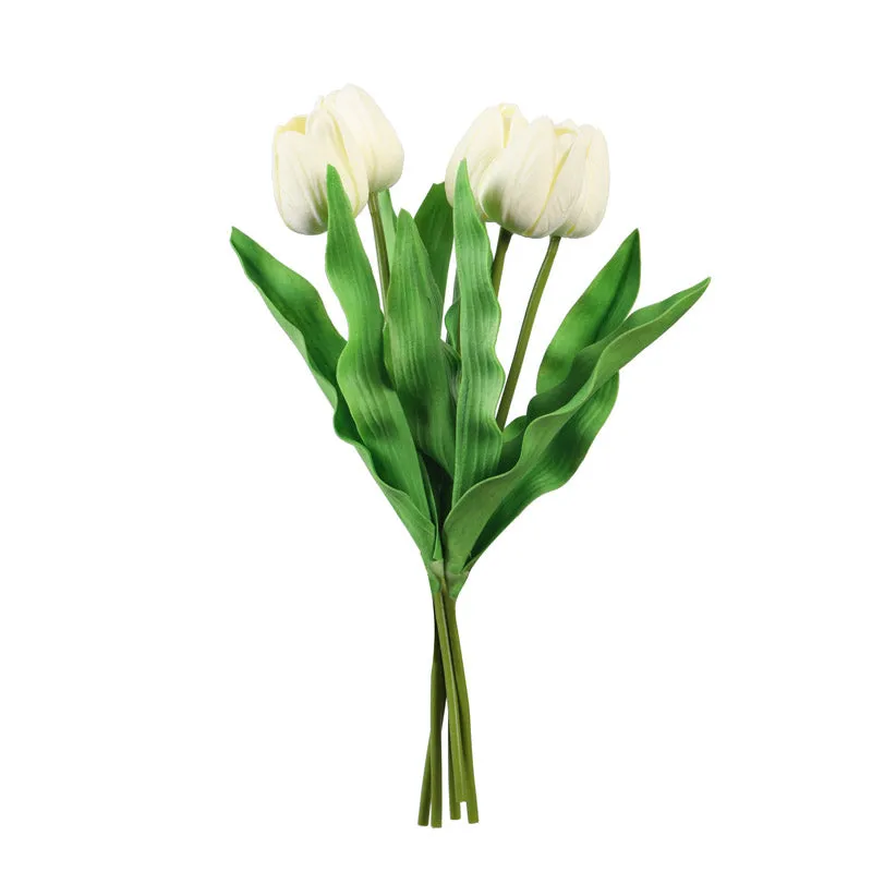 Five white artificial tulip stems with green leaves on a white background
