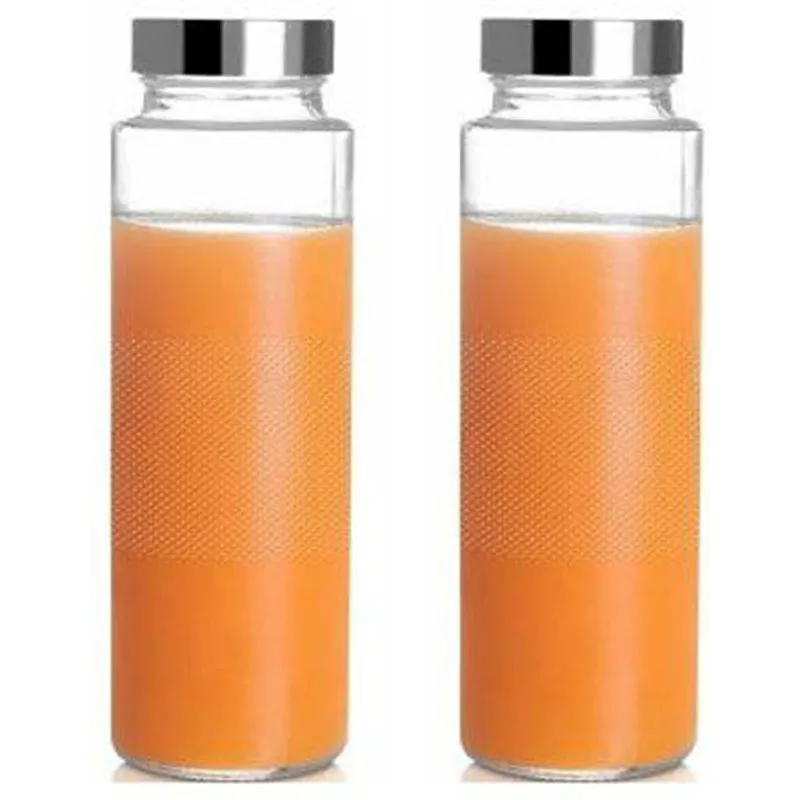 Two transparent glass bottles filled with orange juice