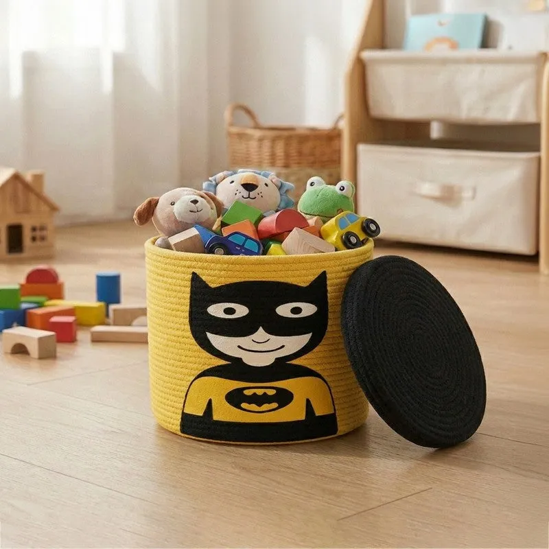 Yellow cylindrical storage basket with black superhero motif and separate black lid
