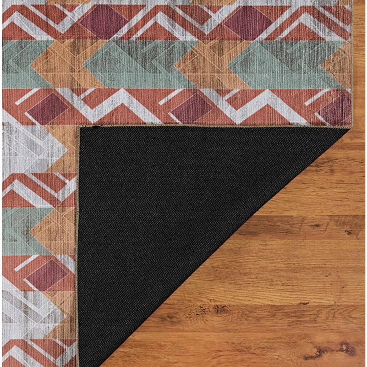 Folded corner of carpet showing black underside and patterned top