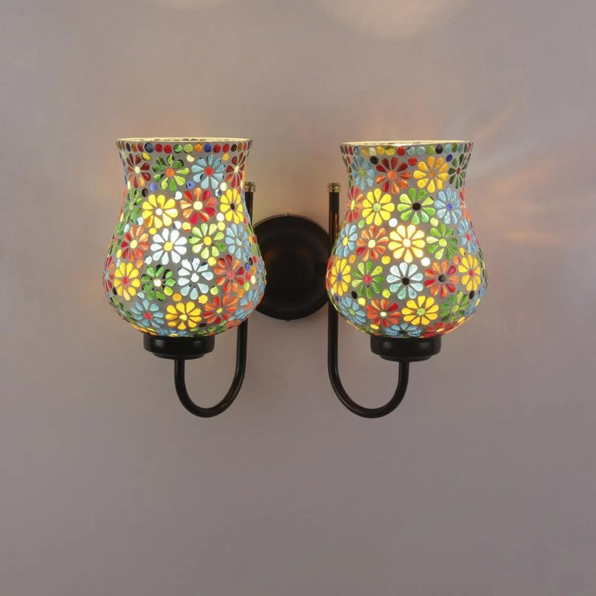 Lit multicolour mosaic twin wall lamp on a plain wall