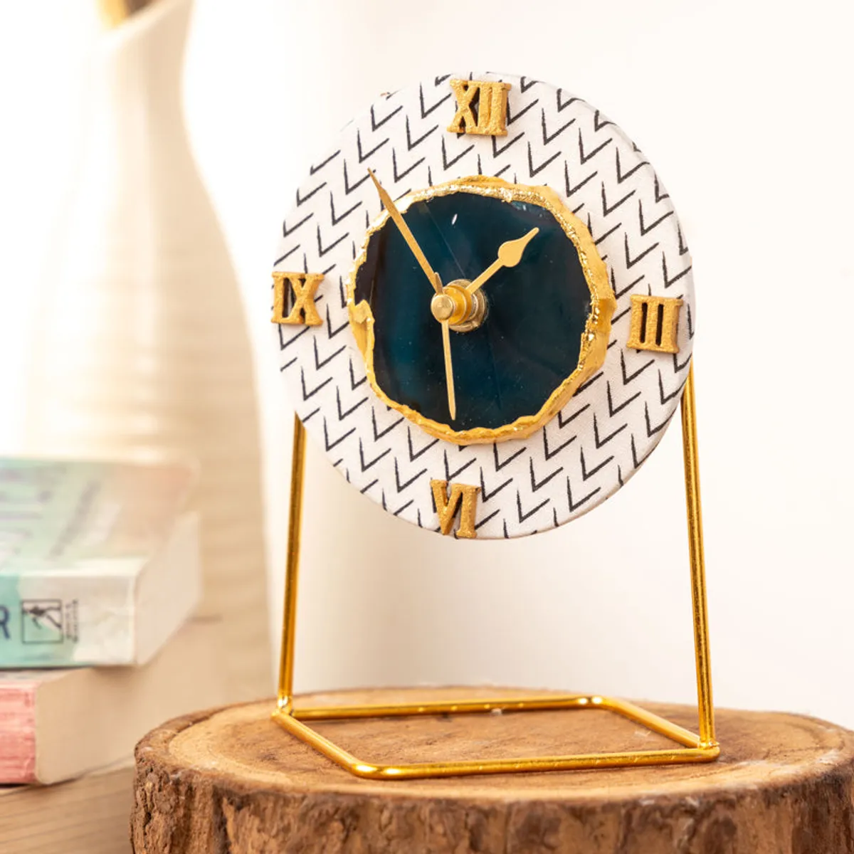 Angled view of a round blue and white clock with gold frame and accents
