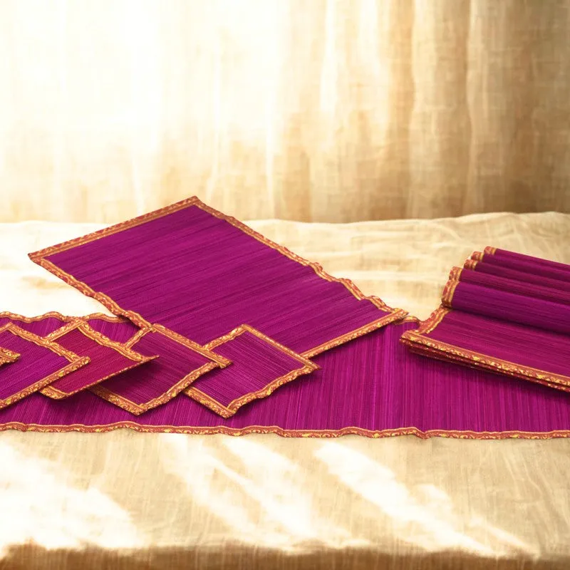 Pink table runner and matching dining mats displayed on a light fabric surface