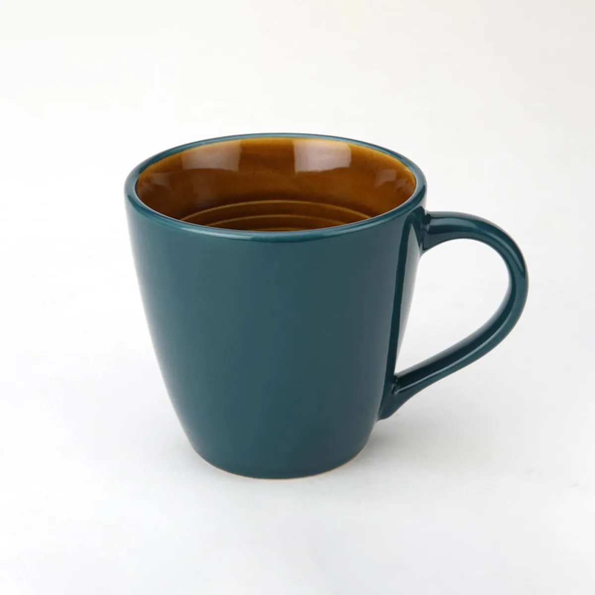 Glossy blue ceramic coffee mug with a warm brown interior on a white background
