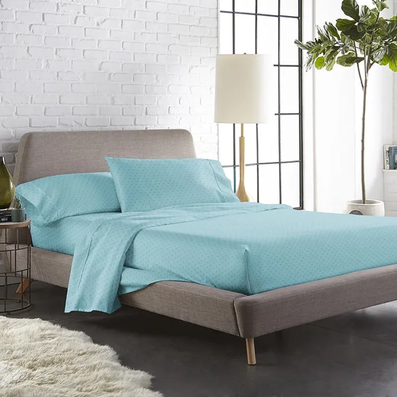 Sky-blue geometric fitted bedsheet styled on a modern bed in a bright bedroom